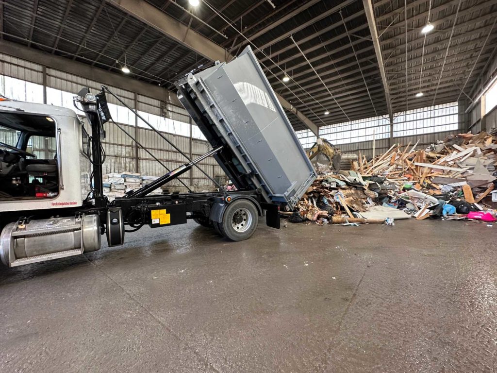 A dumpster being unloaded at a transfer station