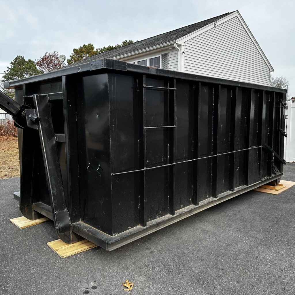 A black 20 yard dumpster placed in a driveway in Wareham