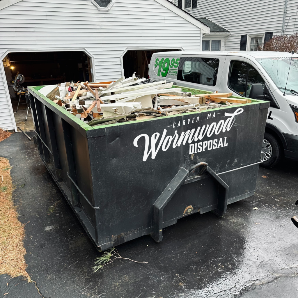 12 Yard dumpster in a driveway full of construction debris