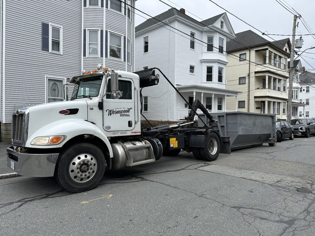 Wormwood Disposal truck unloading a dumpster on the street in New Bedford